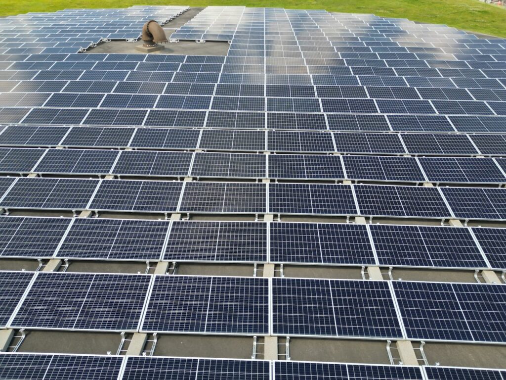 pexels photo 35501735 A large solar panel array on a sunny day in an open green field.